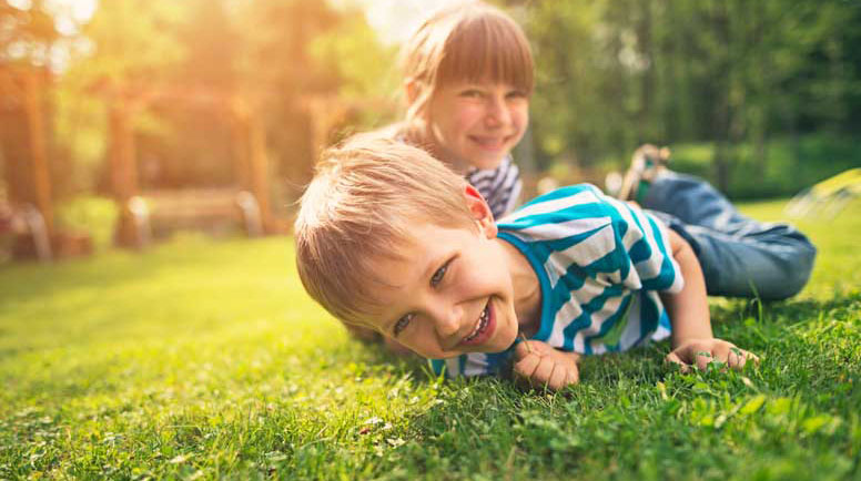 Brother-and-sister-having-fun-on-garden-lawn-000066946465_Large.jpg